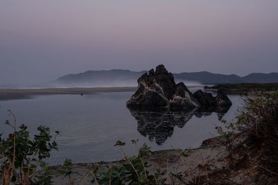 Rock formations in sea against sky