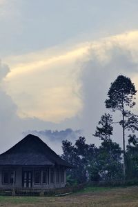 House on field against sky during sunset