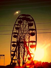 Low angle view of silhouette ferris wheel against sky at sunset