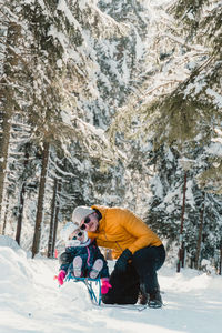 Rear view of man sitting on snow covered mountain