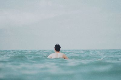 Rear view of shirtless man in swimming pool