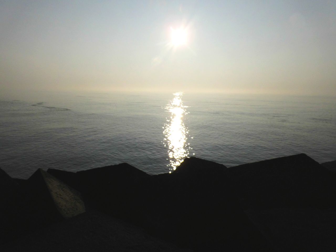 SCENIC VIEW OF SEA AGAINST BRIGHT SUN IN SKY