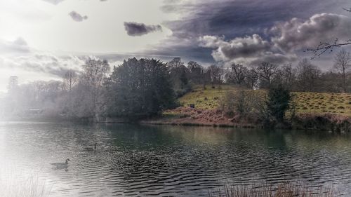 Scenic view of lake against cloudy sky