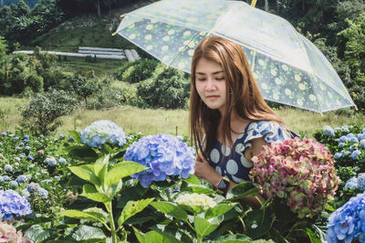 Young woman looking at camera while standing on rainy day