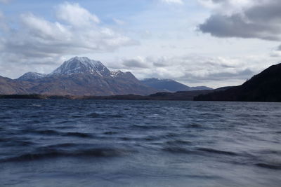 Scenic view of sea and mountains against sky