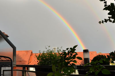 Low angle view of rainbow over building against sky