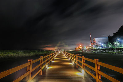 Illuminated bridge against sky at night