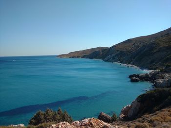 Scenic view of sea and hill against sky