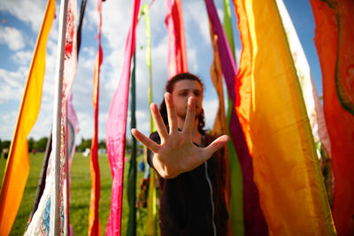 Portrait of young man holding aloft his hand