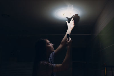 Rear view of woman holding illuminated light