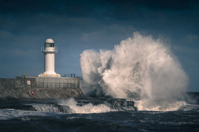 Panoramic view of sea waves against buildings