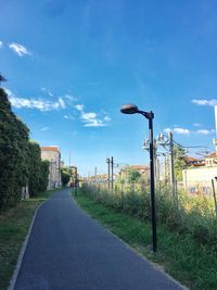 Street by road against blue sky