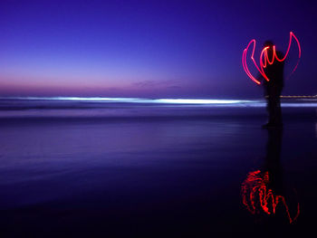 Light painting at beach against sky