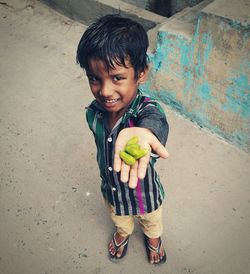 Portrait of smiling boy holding ice cream outdoors