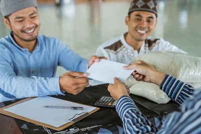 Smiling man receiving receipt at mosque