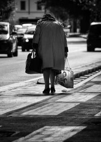 Rear view of woman walking on sidewalk