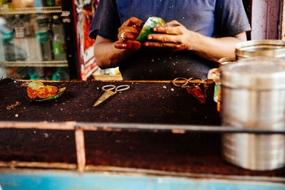 Midsection of man making food in store