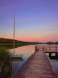 Pier over lake against sky during sunset