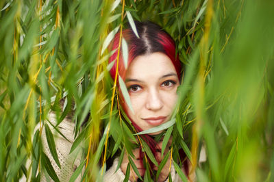Portrait of young woman amidst leaves