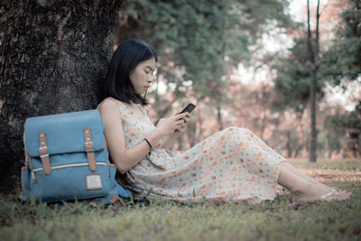 Young man using mobile phone while sitting outdoors