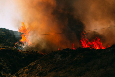 Low angle view of fire against orange sky