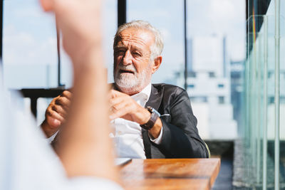 Man looking at camera while sitting on table
