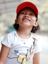 Thoughtful girl smiling while standing outdoors