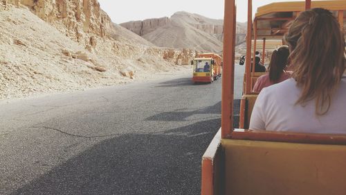 Rear view of man sitting on road