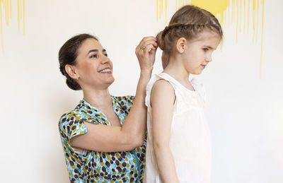 Side view of mother and daughter at home