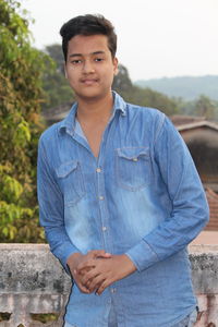 Portrait of man standing by retaining wall