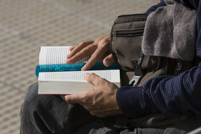Midsection of man reading book