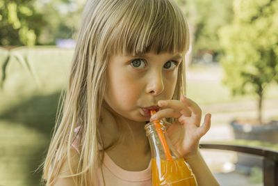 Close-up portrait of girl drinking juice