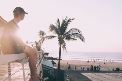 People by swimming pool at beach against sky