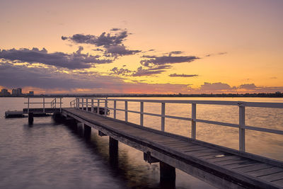 Pier over sea against sky during sunset