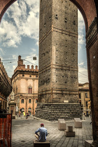 Rear view of people walking in historic building against sky