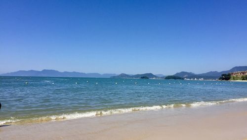 Scenic view of sea against clear blue sky