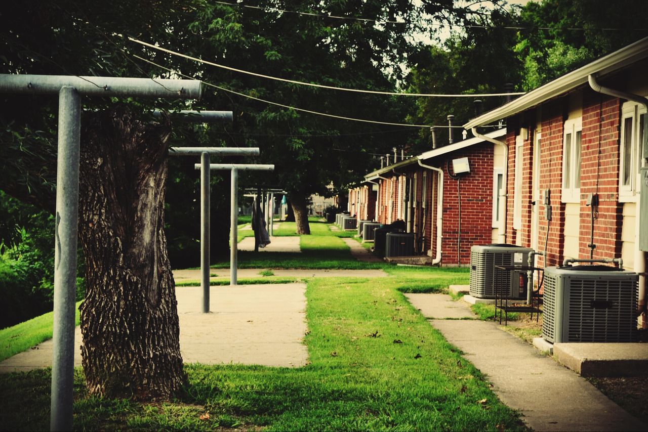 architecture, building exterior, built structure, grass, tree, green color, lawn, empty, city, street light, the way forward, railing, outdoors, footpath, sunlight, walkway, incidental people, house, street, no people