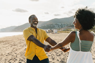 Side view of couple standing at beach