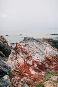 Close-up of rock in sea against sky