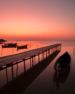 Pier on sea against sky during sunset