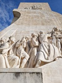 Looking up at landmark monument, with sculptures bathed in light