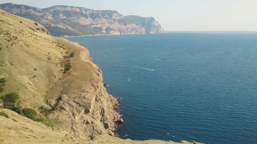 View of calm blue sea against mountain range