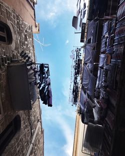 Low angle view of clothes drying on building against sky