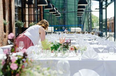 Young woman decorating tables at wedding ceremony event