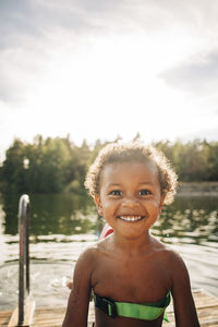 Portrait of shirtless cheerful boy at lake