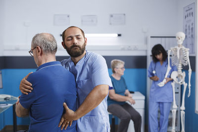 Portrait of male friends standing in hospital