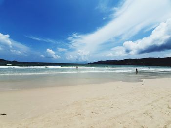 Scenic view of beach against blue sky