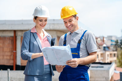 Man wearing hat holding hands while standing outdoors