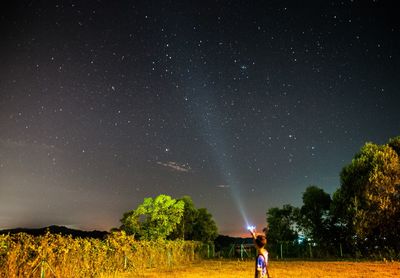 Man standing on field against sky at night