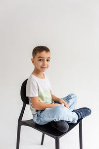 Boy child preschooler smiling and posing on gray background in photo studio